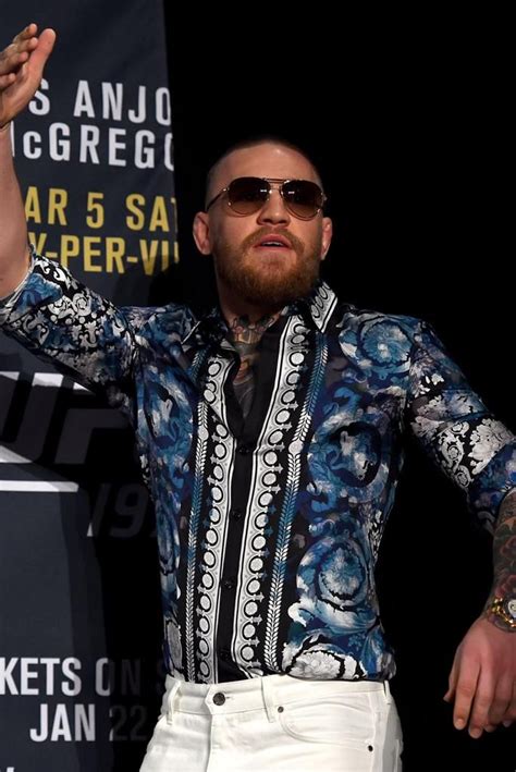 Conor McGregor sports Versace speedos as he waves from back .